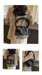 Close-up of black pleated cloud bag featuring premium ruched leather texture and scrunchie handle