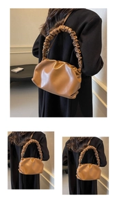 Detail of a brown ruched dumpling bag featuring premium faux leather and pleated texture