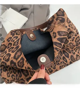 Detail of metal magnetic clasp on leopard print tote bag with high-quality stitching