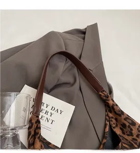 Detail of leopard print canvas tote bag featuring reinforced brown sturdy shoulder straps
