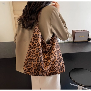 Détail du grand sac hobo à motif léopard porté par un mannequin dans un décor de style rétro
