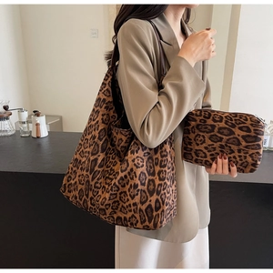 Detail of leopard print tote bag and pouch set with brown leather straps for autumn fashion