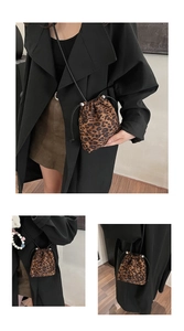 Detail of leopard print drawstring bucket bag showing compact size and styling with trench coat
