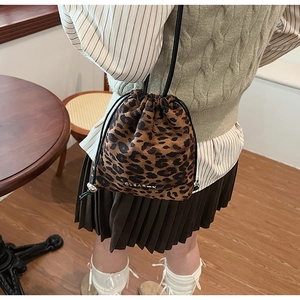 Détail du sac seau léopard avec fermeture à cordon et logo de la marque argenté