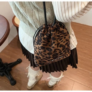 Détail du sac seau à imprimé léopard avec cordon de serrage et lanières noires