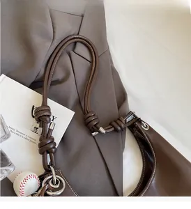 Detail of coffee brown leather tote with knot handle and silver hardware