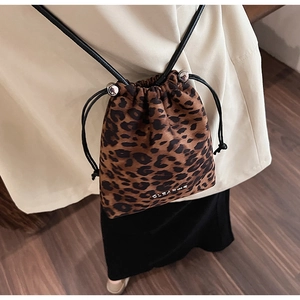 Détail du sac seau à imprimé léopard avec cordon de serrage et œillets en métal argenté