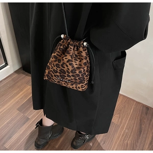 Détail d'un sac seau léopard avec cordon de serrage noir et fermoir en métal argenté