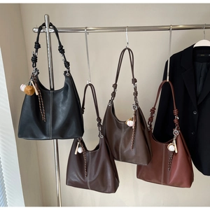 Detail of four retro tote bags with contrast stitching and baseball charm on hangers