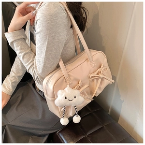 Detail of beige bowling bag with bow accents and cute cloud plush charm accessory