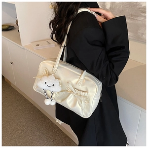 Close-up of cream bow shoulder bag with soft satin finish and cute cloud charm