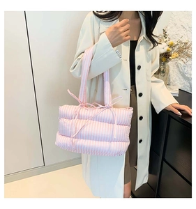 Détail du sac cabas matelassé à rayures roses et blanches avec nœuds aux bandoulières