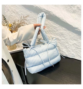 Vue détaillée du sac cabas matelassé à rayures avec nœuds pour le trajet hivernal