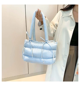 Détail du sac fourre-tout matelassé à rayures bleu clair avec poignée à nœud papillon