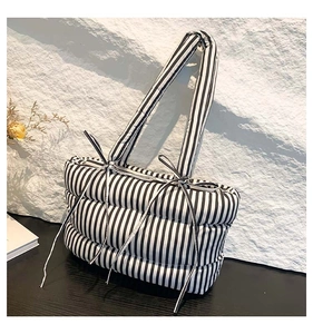 Détail du sac fourre-tout matelassé à rayures noires et blanches avec nœud