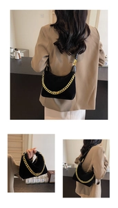 Detail shot of black faux suede hobo bag with gold chain strap for shoulder wear