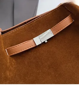 Close-up of brown suede tote bag with leather strap and silver metal square buckle