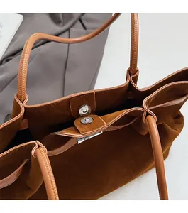 Close-up of silver magnetic closure and interior of the brown suede tote bag