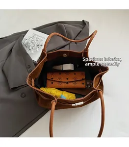 Spacious interior of brown matte bucket bag showing wallet umbrella and phone storage