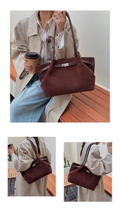 Detail of minimalist dark coffee frosted suede bucket bag with silver metal buckle detail