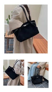 Detail of black matte suede tote bag showing silver metal buckle and soft leather strap