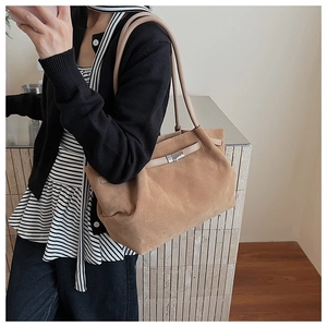 Close-up of brown suede bucket bag featuring elegant silver metal buckle and slim strap