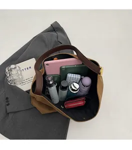 Top view of spacious brown tote bag interior holding tablet, umbrella and cosmetics