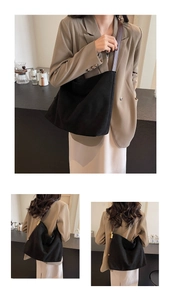 Detail of black suede tote bag featuring brown leather shoulder straps and gold hardware