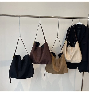 Detail of minimalist suede tote bag strap with gold adjustable metal buckle
