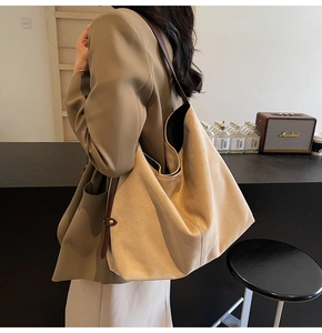 Detail view of large capacity suede tote bag with slim brown leather strap and metal buckle