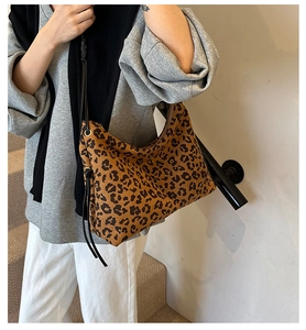Close-up of leopard print tote bag featuring black side drawstrings and smooth zipper detail