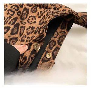 Close-up of golden magnetic metal buckle on a leopard print canvas tote bag detail