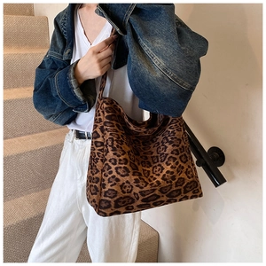 Detailed close-up of large leopard print hobo bag with wide strap and canvas texture