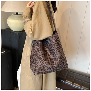 Detailed view of leopard print tote bag styled with a beige trench coat for autumn