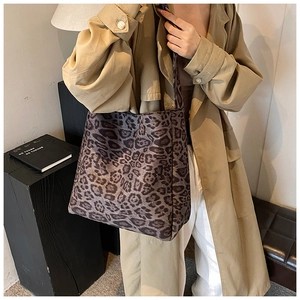 Detail of leopard print tote bag on shoulder, featuring soft fabric and large capacity