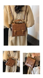 Detail showing vintage brown leather backpack with metal buckles and handle grip