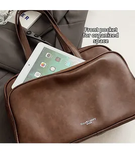 Brown leather Boston bag detail showing large front pocket with tablet for storage