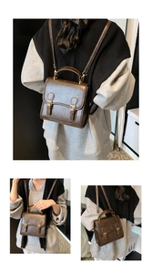 Detail view of a vintage dark brown PU leather backpack with gold buckle closures