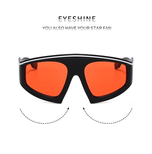 Detail of oversized black frame sports sunglasses with vibrant orange mirrored shield lens