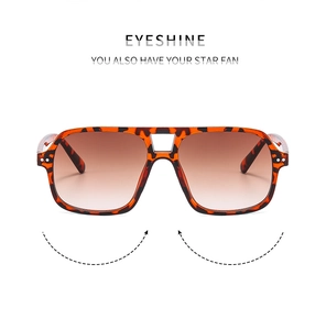 Detailed view of tortoiseshell aviator sunglasses with brown gradient lenses and metal rivets