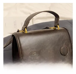 Close-up of retro brown PU leather handbag showing lychee texture and gold metal hardware