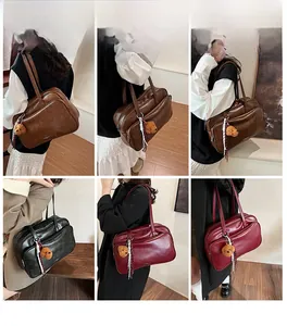 Detail showing high-capacity Boston bags in brown, black, and red with bear pendant