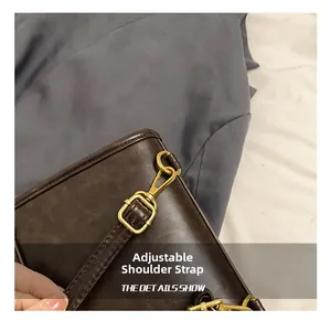 Detail of adjustable strap on vintage dark brown leather bag with gold-tone hardware