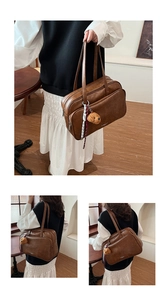 Detail view of large dark brown retro boston bag with cute puppy plush charm accessory