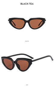 Detail view of cat eye sunglasses with black glossy frames and black-tea lenses