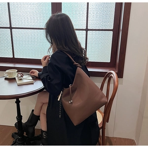 Secchiello in pelle marrone scuro con coulisse in un ambiente da caffè vintage
