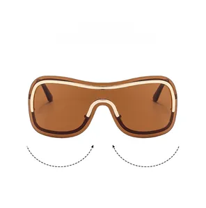 Detail einer übergroßen randlosen Sonnenbrille mit braunem Shield-Glas und goldener Metallleiste