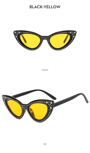 Detail of cat eye sunglasses with rhinestones, silver stars and yellow lenses
