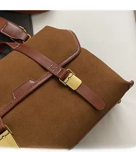 Close-up of vintage brown frosted suede texture with contrast stitching and antique gold buckle