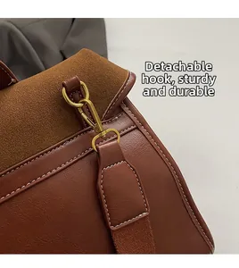 Detail of vintage brown leather backpack with gold metal hooks and white stitching